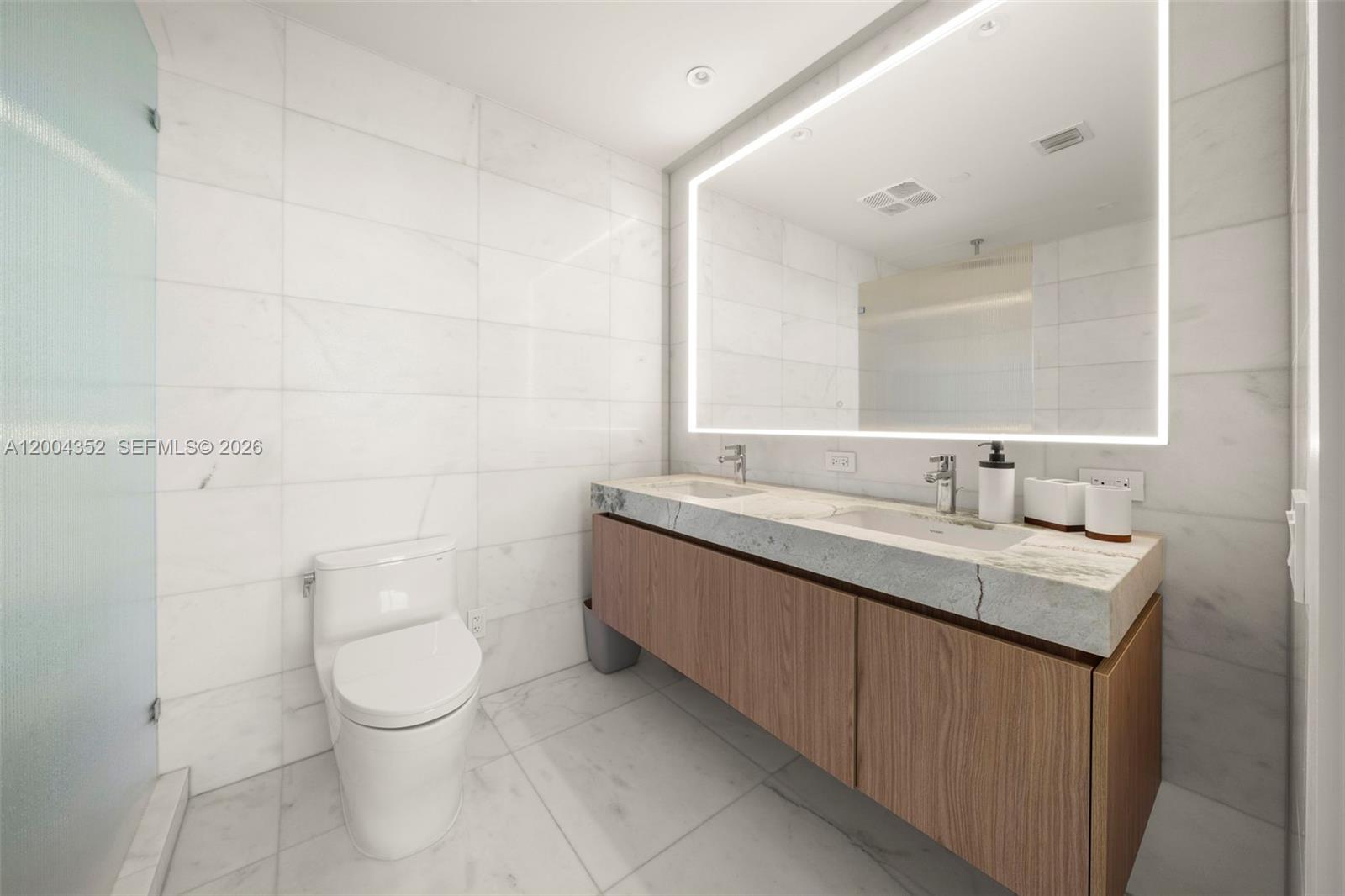 500 Alton Road, Unit 1707 Miami Beach, FL 33139 - Photo 35 of 52 a bathroom with a granite countertop sink a toilet and a mirror