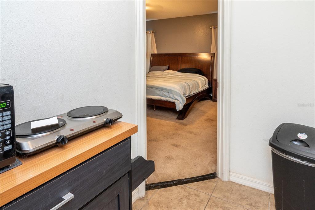 4563 Orchard Grove Road St. Cloud, FL 34772 - Photo 17 of 51 a bedroom with a bed and a lamp on the dresser