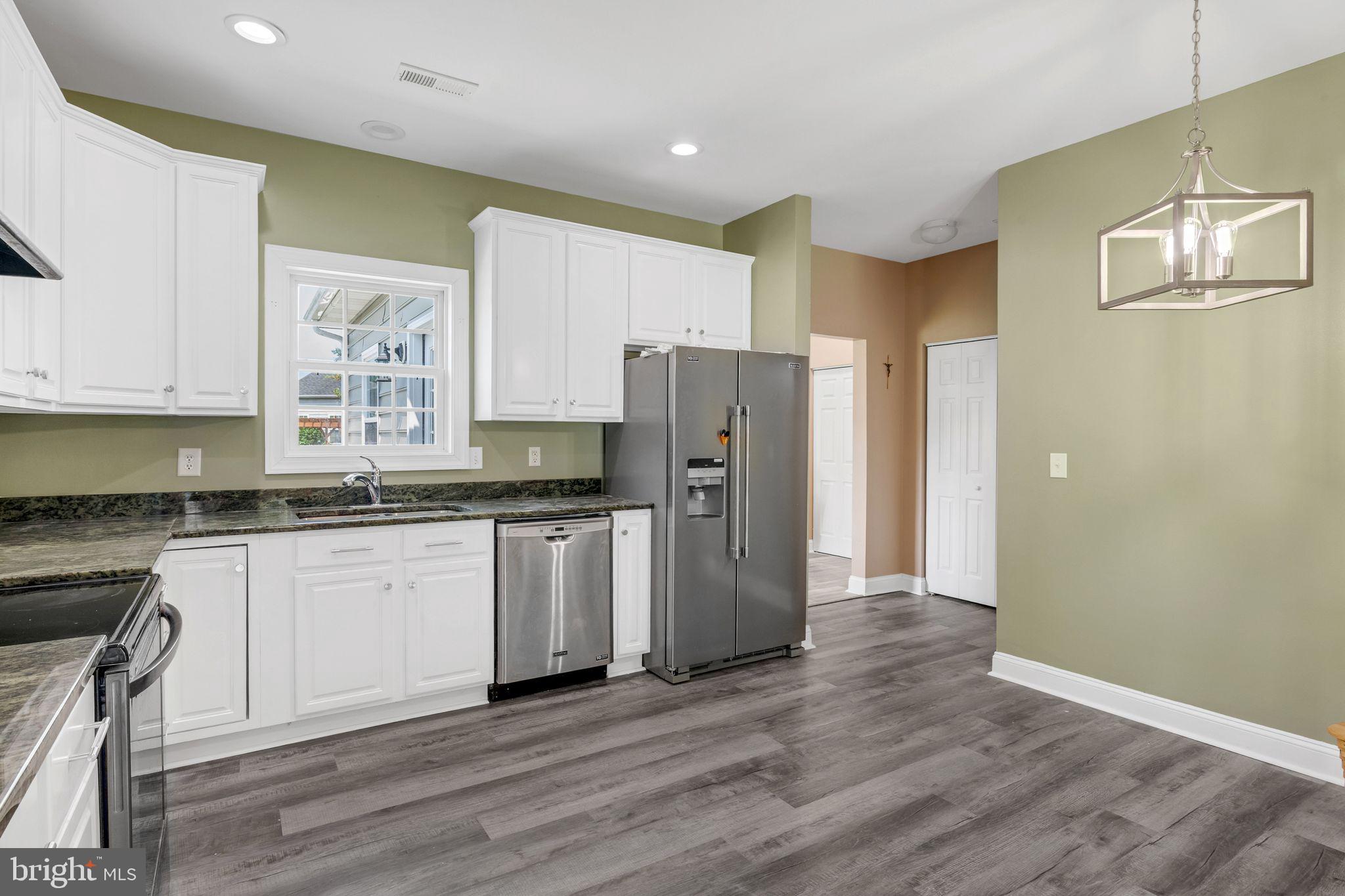 27407 Walking Run Milton, DE 19968 - Photo 11 of 25 a kitchen with granite countertop a refrigerator stove and sink