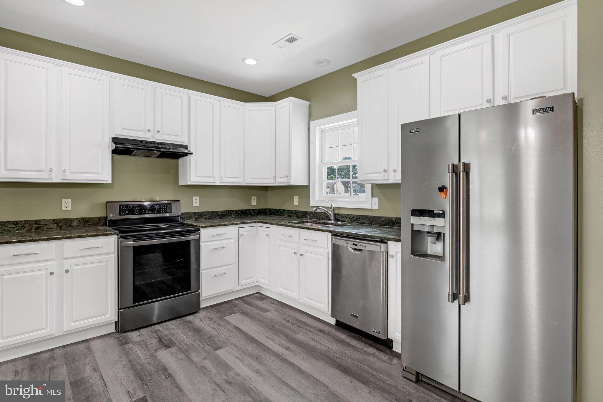 27407 Walking Run Milton, DE 19968 - Photo 12 of 25 a kitchen with stainless steel appliances a refrigerator sink and microwave