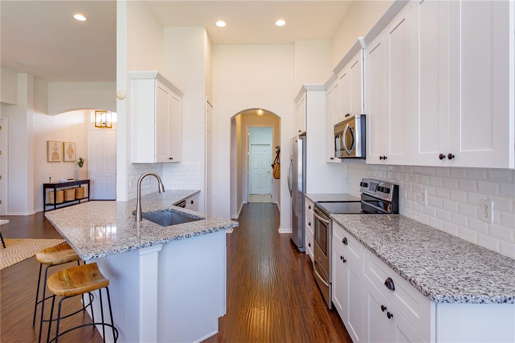 1572 St Regis Point Sanford, FL 32771 - Photo 11 of 30 a kitchen with granite countertop a sink stove and cabinets