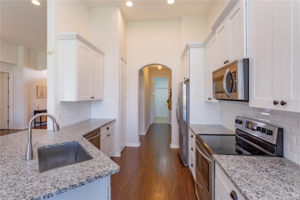 1572 St Regis Point Sanford, FL 32771 - Photo 12 of 30 a kitchen with stainless steel appliances granite countertop a sink stove and refrigerator