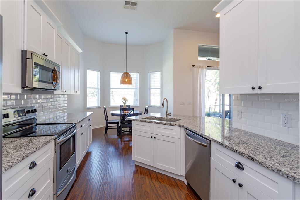 1572 St Regis Point Sanford, FL 32771 - Photo 13 of 30 a kitchen with granite countertop lots of counter top space a sink stainless steel appliances and cabinets