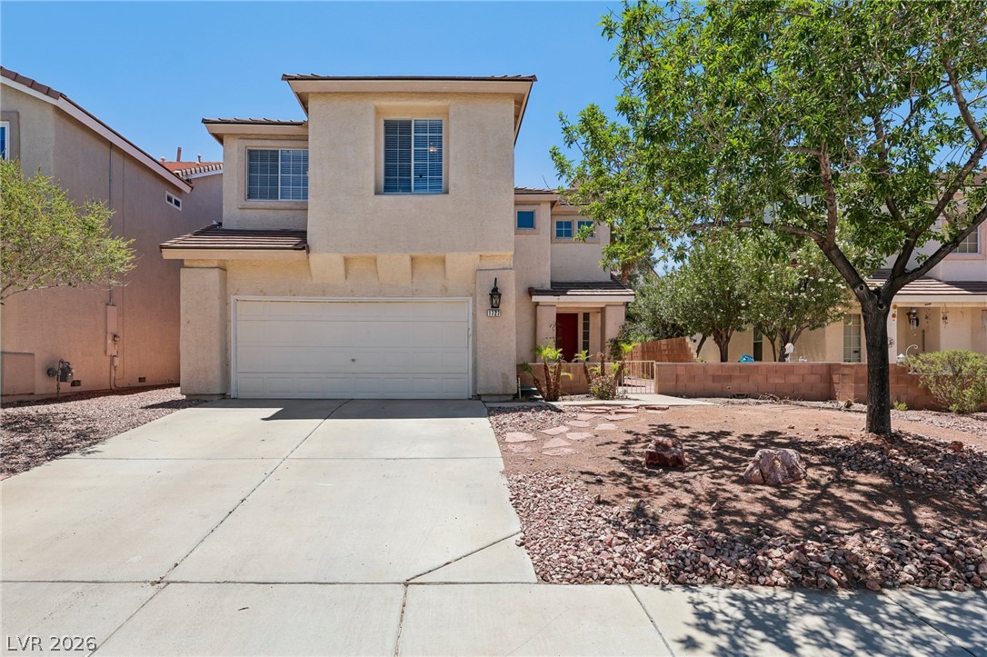 1727 Millstream Way Henderson, NV 89074 - Photo 1 of 46 A well-kept front yard offers concrete driveway, desert landscaping, and inviting red entry door.