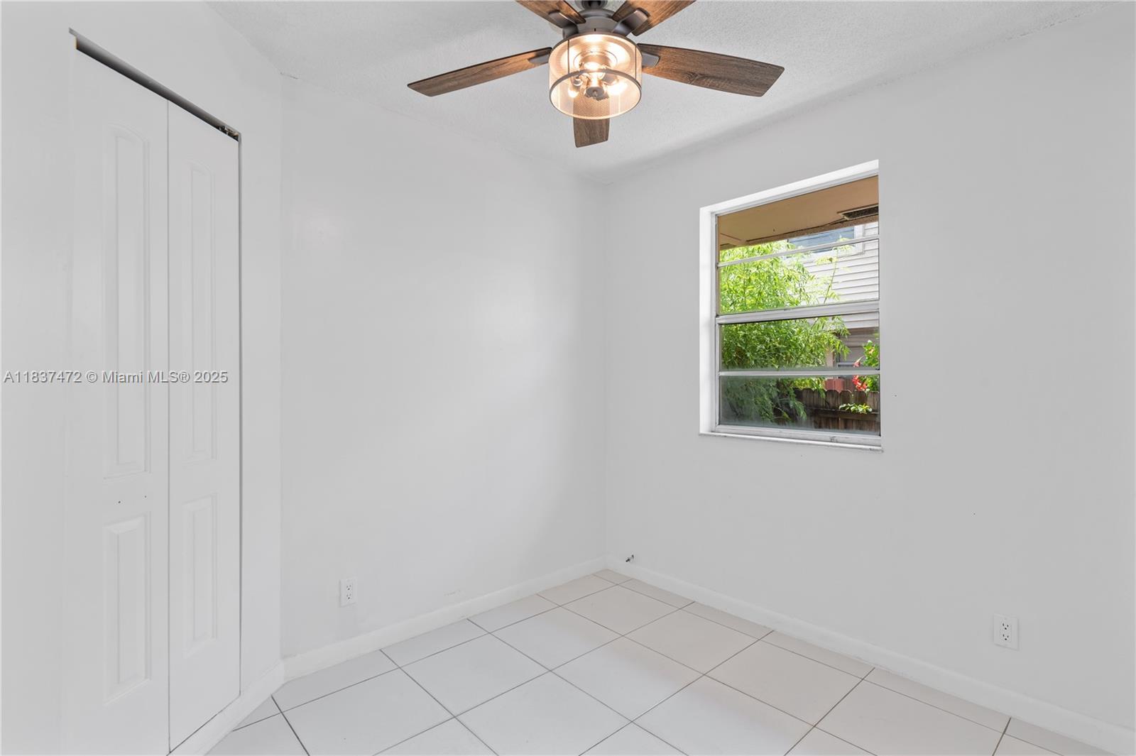 6603 Winfield Boulevard, Unit B2 Margate, FL 33063 - Photo 13 of 28 an empty room with windows and fan