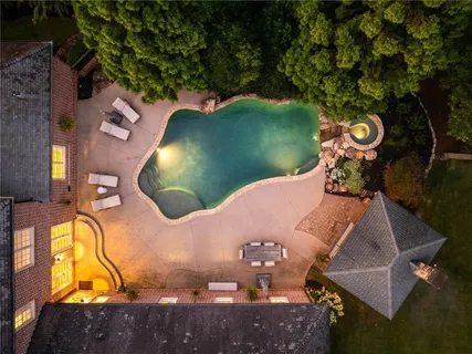 an aerial view of a house with a swimming pool patio and outdoor seating