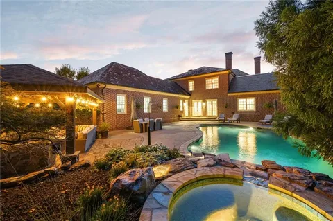a front view of a house with swimming pool having outdoor seating