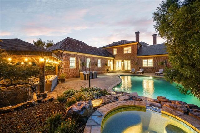 a front view of a house with swimming pool having outdoor seating