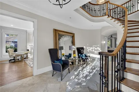 a living room with furniture large window and wooden floor
