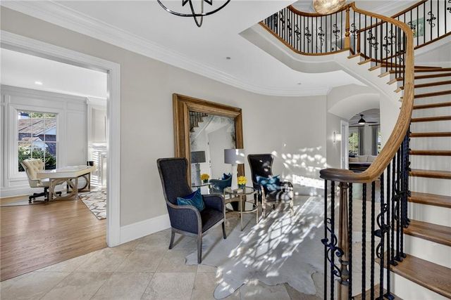 a living room with furniture large window and wooden floor