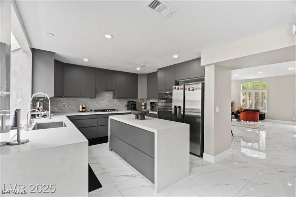 9416 Rolling Ridge Lane Las Vegas, NV 89134 - Photo 13 of 34 Kitchen featuring gray cabinets, modern cabinets, appliances with stainless steel finishes, backsplash, and recessed lighting