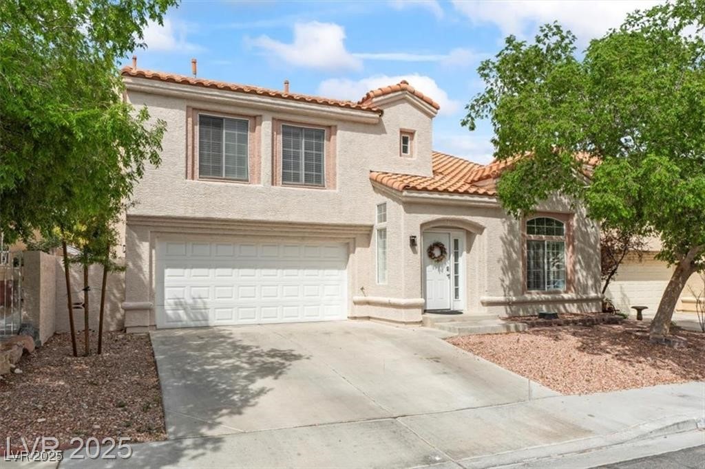 9416 Rolling Ridge Lane Las Vegas, NV 89134 - Photo 2 of 34 Mediterranean / spanish-style house with driveway, stucco siding, a garage, and a tiled roof