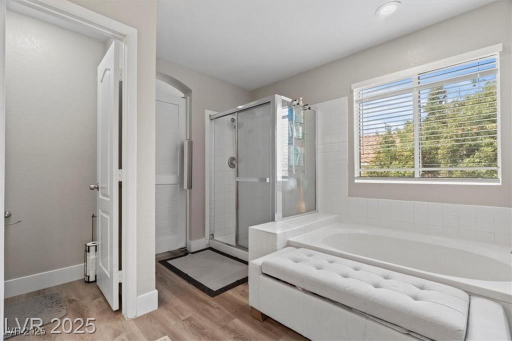 9416 Rolling Ridge Lane Las Vegas, NV 89134 - Photo 24 of 34 Bathroom with a shower stall, a garden tub, and light wood finished floors