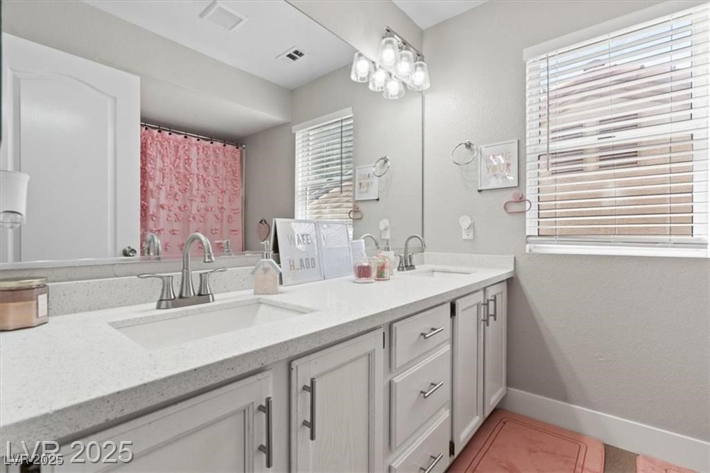 9416 Rolling Ridge Lane Las Vegas, NV 89134 - Photo 26 of 34 Full bathroom featuring double vanity, a textured wall, and a shower with curtain
