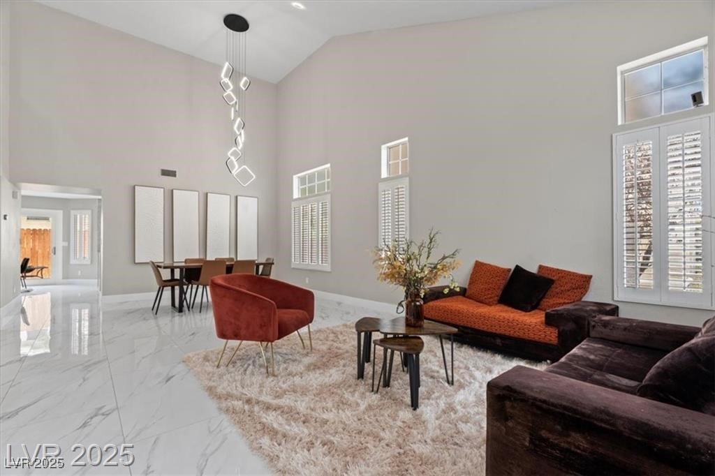 9416 Rolling Ridge Lane Las Vegas, NV 89134 - Photo 4 of 34 Living area with light marble finish flooring and high vaulted ceiling