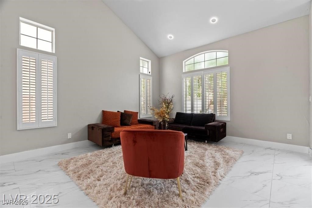 9416 Rolling Ridge Lane Las Vegas, NV 89134 - Photo 7 of 34 Living area featuring high vaulted ceiling, light marble finish flooring, and recessed lighting