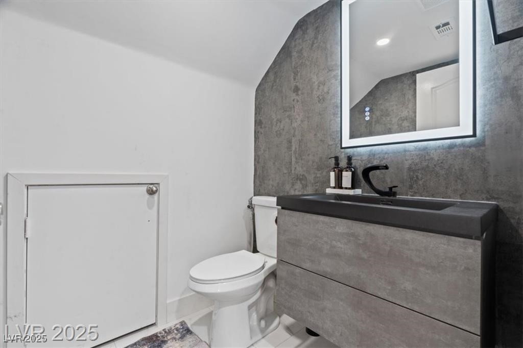 9416 Rolling Ridge Lane Las Vegas, NV 89134 - Photo 10 of 34 Half bathroom featuring lofted ceiling, vanity, and tile patterned flooring