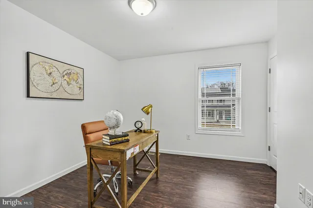 a view of a workspace with furniture and wooden floor