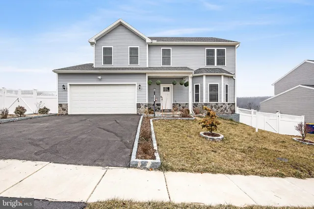 a view of a white house with large windows next to a road