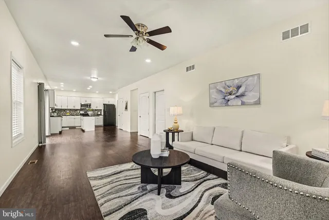 a living room with furniture and kitchen view