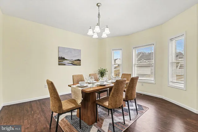 a dining room with furniture a chandelier and wooden floor
