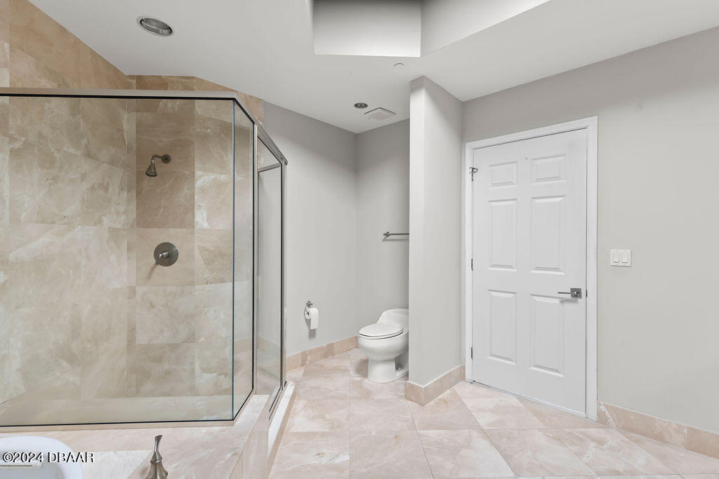 241 Riverside Drive, Unit 2610 Daytona Beach, FL 32117 - Photo 18 of 31 a bathroom with a granite countertop shower and a toilet