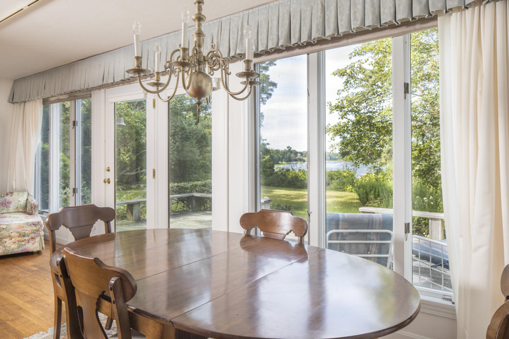 22 Jack Knife Point Road Orleans, MA 02653 - Photo 27 of 37 a dining room with wooden floor glass table and chairs