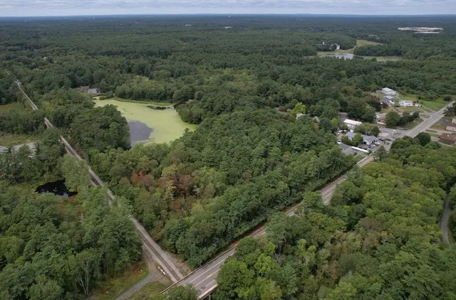an aerial view of residential houses with outdoor space and trees
