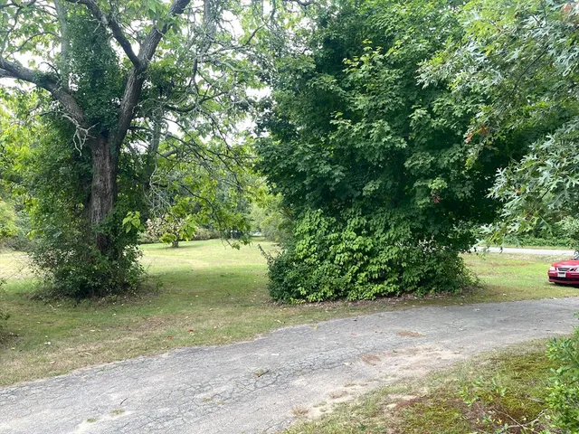 a front view of a house with a yard and trees