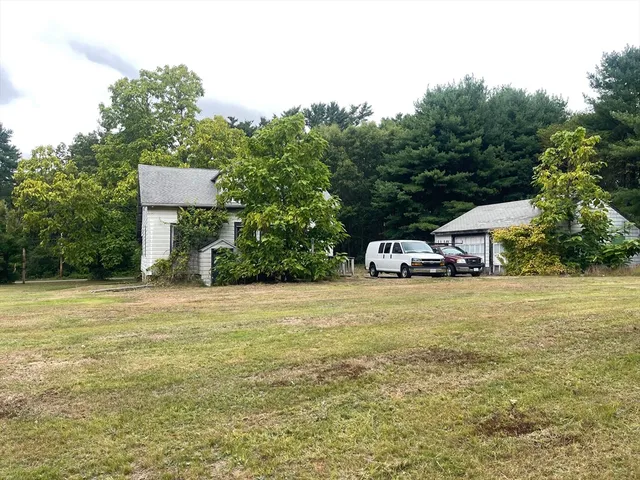 a white house with a yard and plants