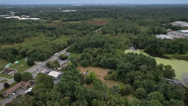 an aerial view of residential house with outdoor space and trees all around