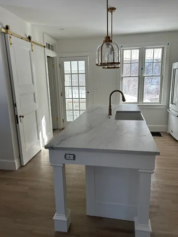 a kitchen with kitchen island a large counter appliances and a window
