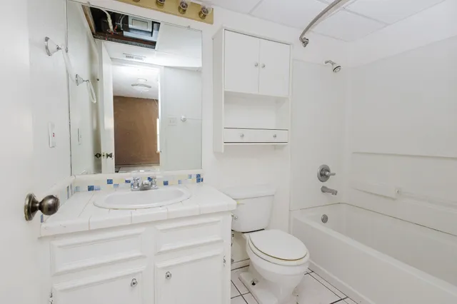 a bathroom with a sink toilet vanity and shower