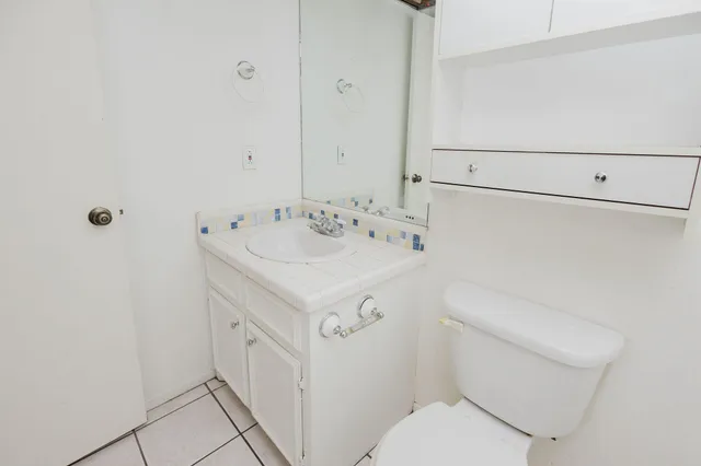 a bathroom with a sink a toilet and a mirror