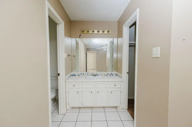 a spacious bathroom with a granite countertop sink and a mirror
