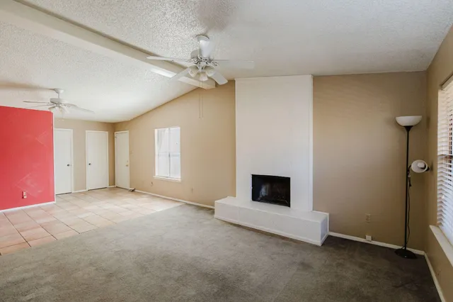 a view of empty room with fireplace and fan