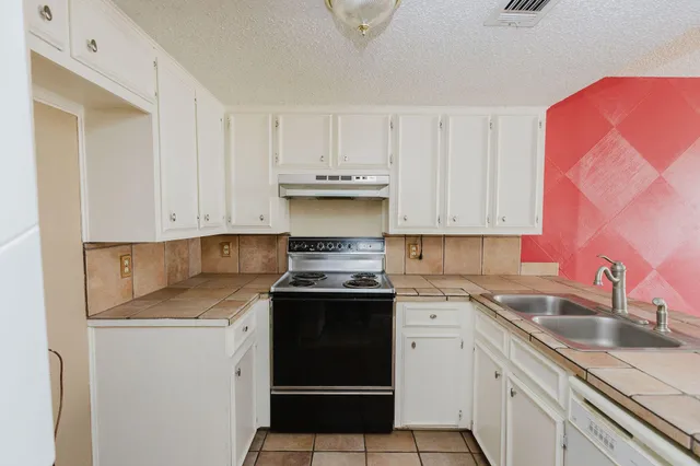 a kitchen with stainless steel appliances granite countertop a sink stove and cabinets
