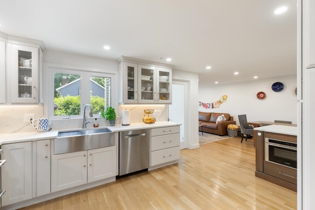 155 Adams Avenue Newton, MA 02465 - Photo 13 of 37 a large white kitchen with stainless steel appliances granite countertop a stove and a sink