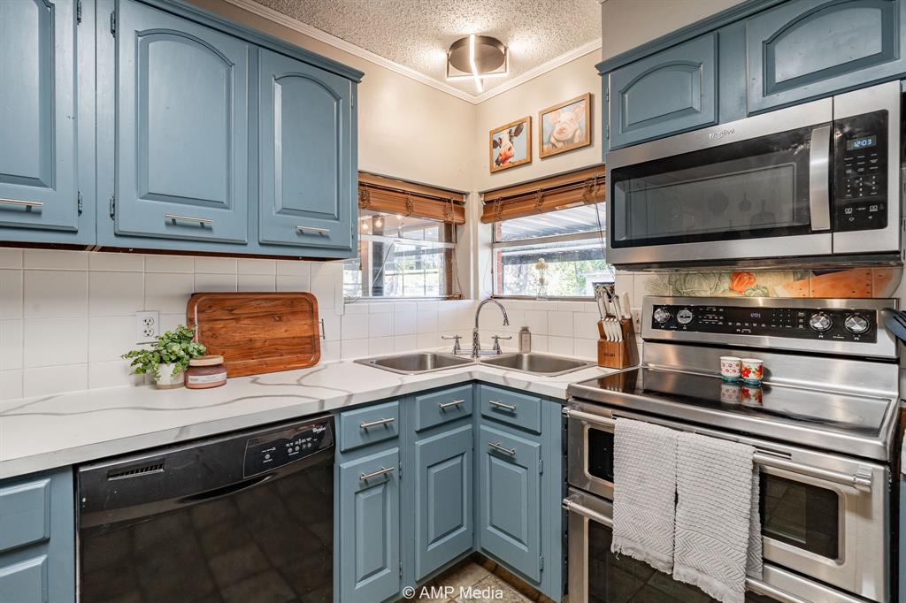 1309 Hudson Road Stamford, TX 79553 - Photo 12 of 35 a kitchen with stainless steel appliances a stove microwave and sink