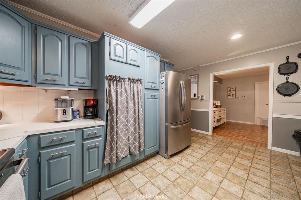1309 Hudson Road Stamford, TX 79553 - Photo 13 of 35 a kitchen with stainless steel appliances a refrigerator and cabinets
