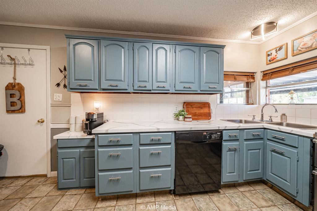 1309 Hudson Road Stamford, TX 79553 - Photo 14 of 35 a kitchen with granite countertop a sink and cabinets