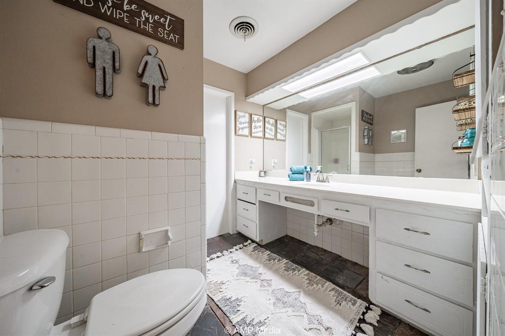 1309 Hudson Road Stamford, TX 79553 - Photo 22 of 35 a bathroom with a sink a toilet and mirror