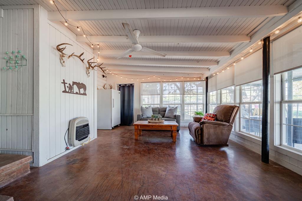 1309 Hudson Road Stamford, TX 79553 - Photo 25 of 35 a living room with furniture floor to ceiling window and wooden floor