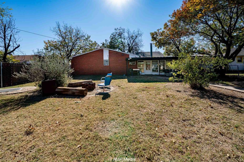 1309 Hudson Road Stamford, TX 79553 - Photo 33 of 35 a backyard of a house with table and chairs under an umbrella