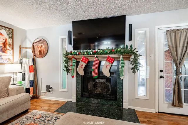 a living room with furniture a flat screen tv and a floor to ceiling window