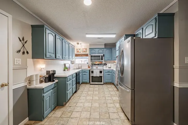 a kitchen with a refrigerator a sink and cabinets