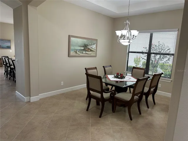 a view of a dining room with furniture a chandelier and window