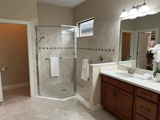 a bathroom with a shower sink and mirror