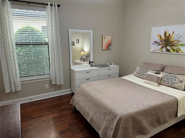 a bedroom with a bed and a painting on the wall