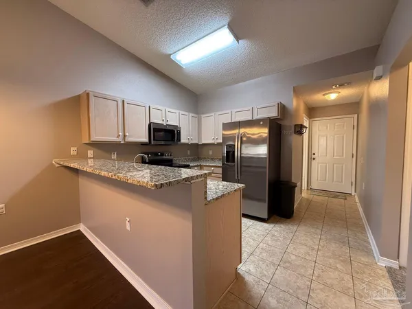 a kitchen with stainless steel appliances granite countertop a refrigerator stove and oven